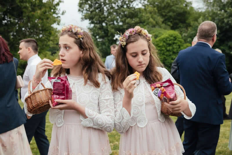 Twin bridesmaids enjoy canapes at a U.K. wedding. Champagne Taittinger Wedding Food Photographer. | Emma Stoner/World Food Photography Awards sponsored by Bimi