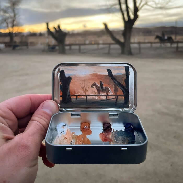 These 40 Tiny Altoid Tin Paintings by Remington Robinson Are Pure Pocket-Sized Magic 50 A hand holds an open Altoid tin at sunset, revealing a miniature painting by Remington Robinson of a rider on horseback framed by bare trees and a fence, with a small earthy-toned paint palette arranged in the bottom half.
