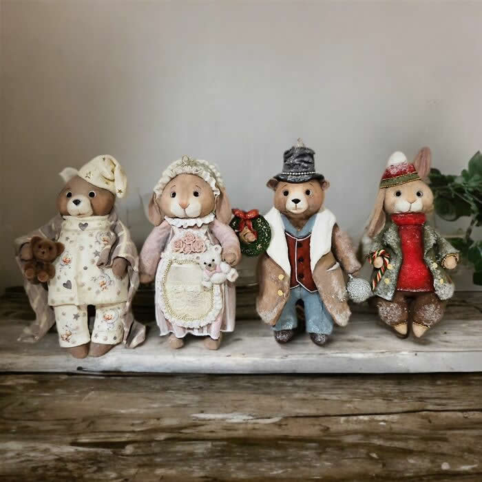 A group of handcrafted miniature cotton wool animal ornaments stands together on a tray, including bears and rabbits dressed in cozy winter clothing and vintage-inspired holiday outfits, each with its own charming personality and handmade details.