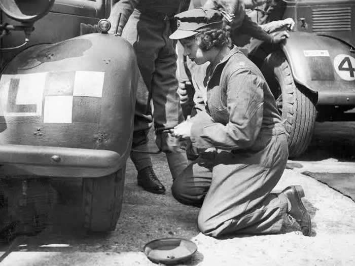 Queen Elizabeth changing a tire on a truck during WWII