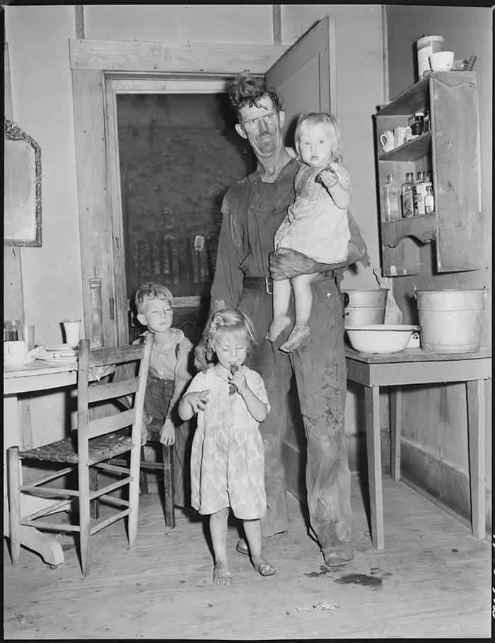 A 60-year-old man poses with his family of three in Kentucky, 1946