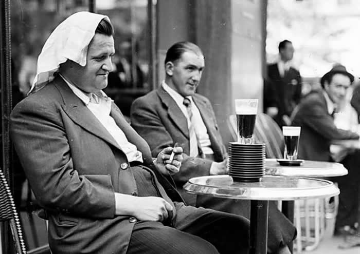 Overwhelmed by the summer heat, a man sits before a stack of saucers marking the number of drinks he had consumed so far. Paris, France, June 1941, during World War II