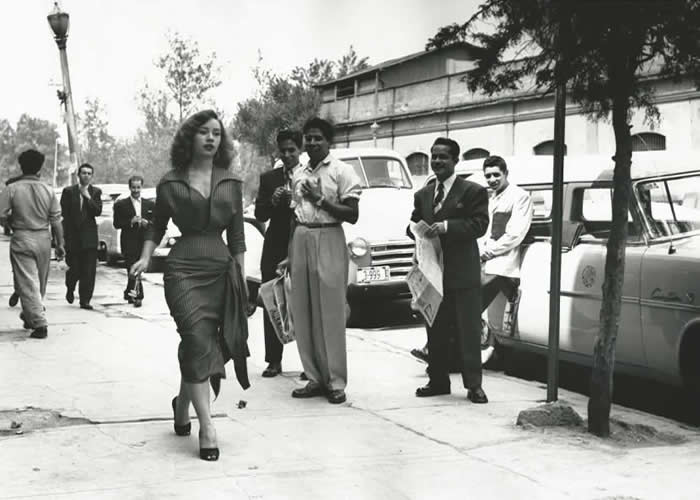 Nacho Lopez, Mexican photographer, decided to do a social-cultural experiment and asked actress Maty Huitron to go to the market while he went back to get more roll, then he hide and took photos while he followed her, capturing the reactions of the men. Done January of 1953