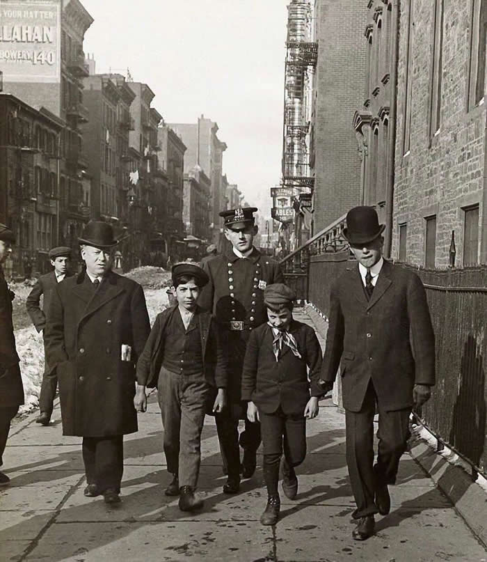 Two boys being arrested for pickpocketing. New York, early 1900s