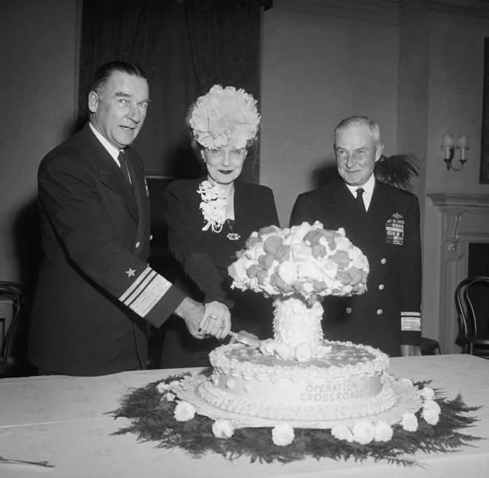 Admiral William H.P. Blandy and his wife cut into a mushroom cloud cake, celebrating the 1946 atomic tests on Bikini Atoll