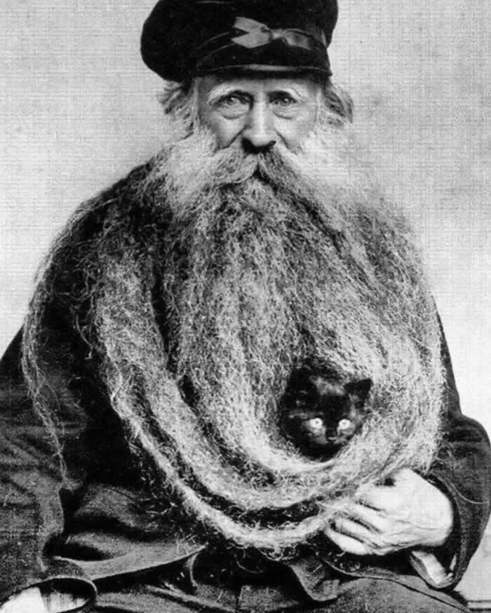 Back in 1904, Louis Coulon made headlines with his extraordinary 11-foot-long beard (3.35 meters), which he even used as a cozy resting spot for his beloved cats. - Animals Stole the Spotlight Historic Photos