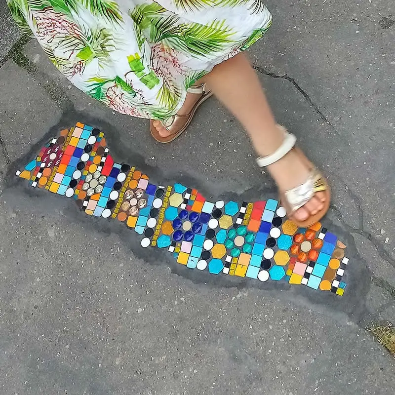 Decorating the sidewalk in front of Dampierre school with mosaics.