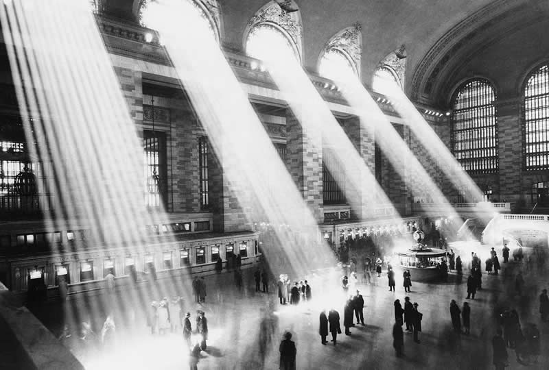 1930. People going about their business in the Grand Central Station Lobby as the Sun Beams Spectacularly Through the Windows