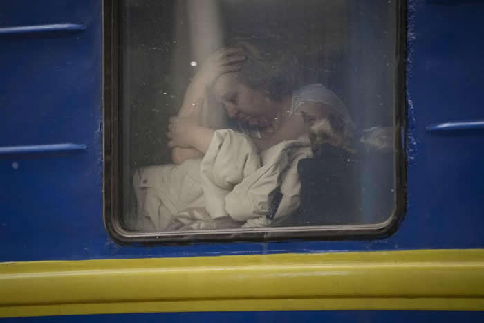 Woman sits by the window of a Lviv-bound train. AP - Photos looks like Paintings