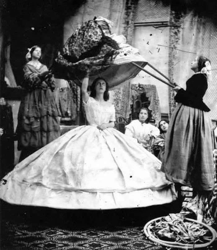 How many Victorians does it take to put on a dress? Crinolines (the hoop) were hazardous if worn without due care. Thousands of women died in the mid-19th century as a result of their hooped skirts catching fire, or getting caught in machinery, carriage wheels, gusts of wind, or other obstacles.