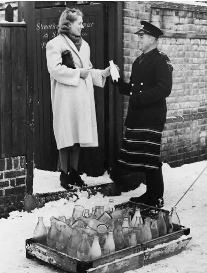 A milkman makes a delivery to Streatham Grammar school in London. 1939.