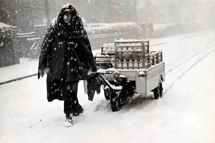 The milk man out delivering in a snow storm, Manchester, Great Britain, 1946.