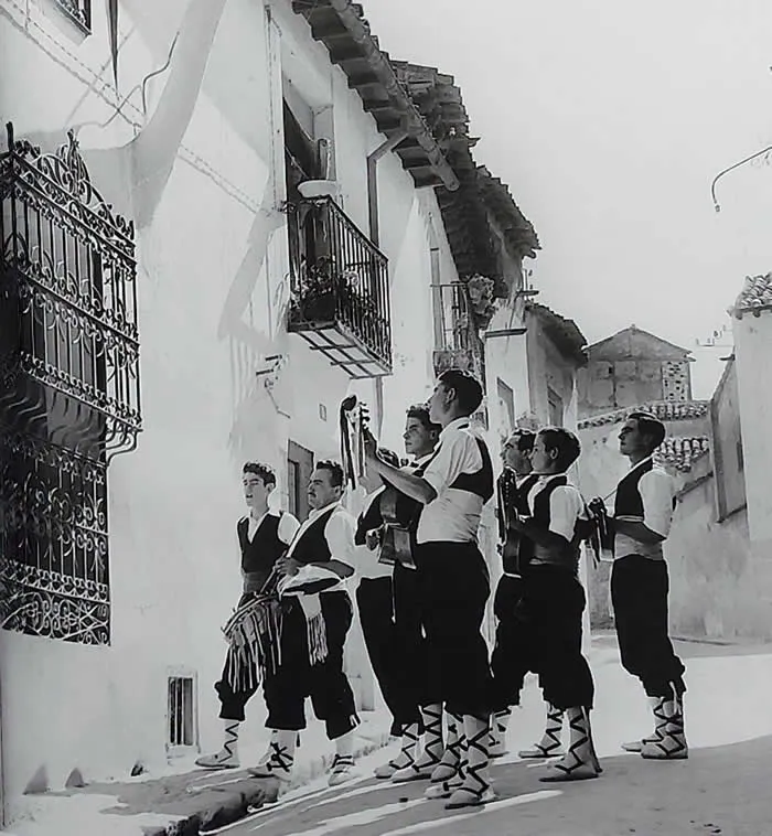 Singing for a friend. Youngsters hired to serenade a girl under her window, in a village in Spain (1952).