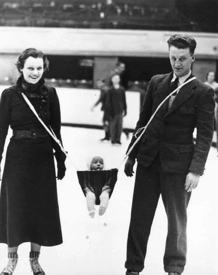 Parents taking their baby ice skating, ca. 1930s.