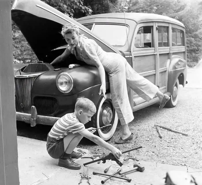 With her husband at war, Mom works on the car, ca. 1944. (Photo by LlFE Magazine)