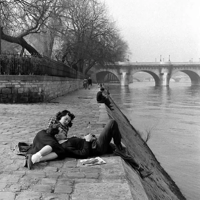 A couple relaxing on the banks of the Seine River in Paris, France (1949). Photo by Nat Farbman.