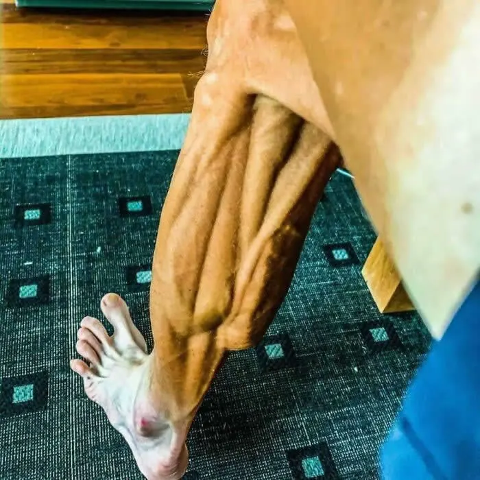 Close-up of former professional cyclist Janez Brajkovič&rsquo;s heavily veined, muscular leg and foot after a race, showing prominent tendons and defined muscles.