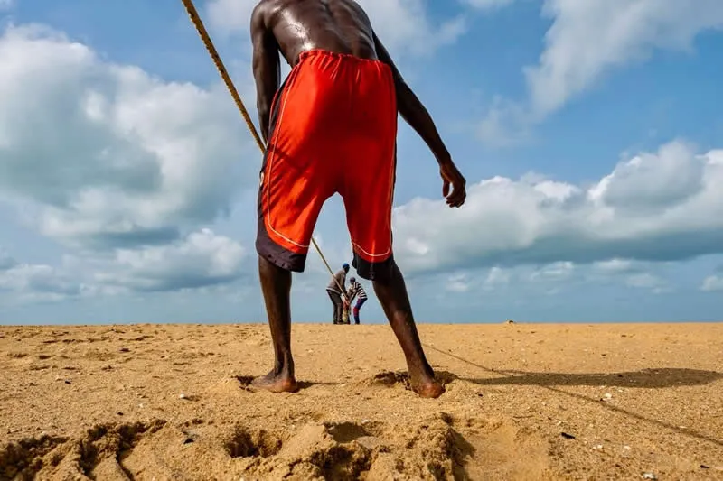 Capturing Humanity: Award-Winning Photographer France Leclerc Explores Life Around the World 55 On the coast near Ouidah, Benin, men pulling huge fishing nets from the water - Street and Documentary Photography by France Leclerc