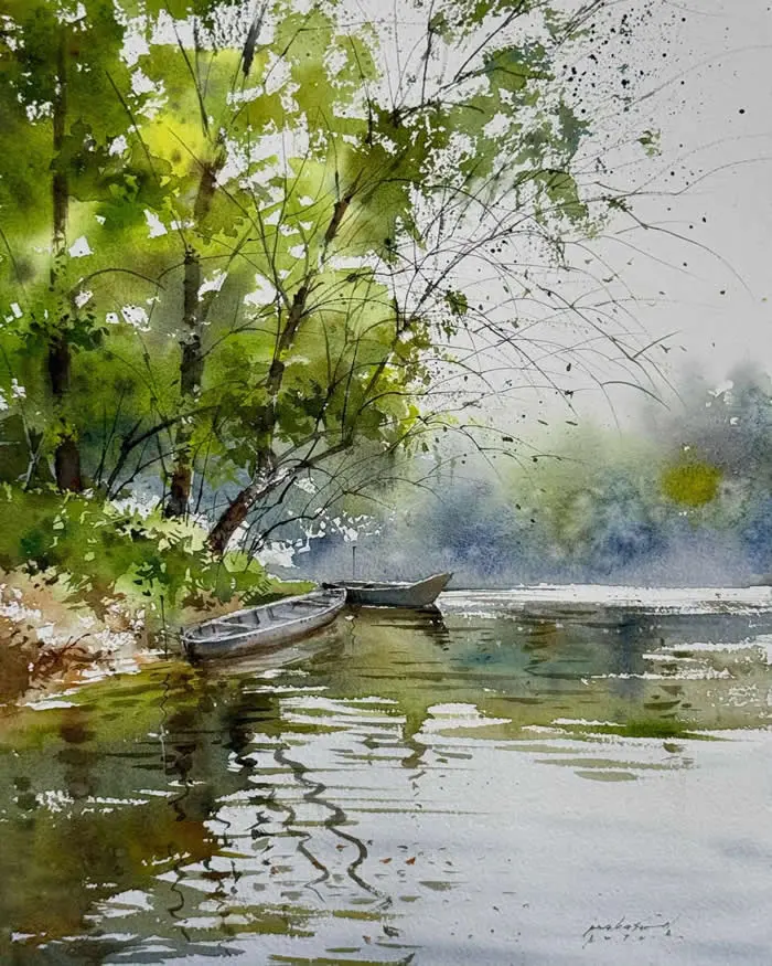 Watercolor painting by Indian artist Prakashan Puthur titled Boats, depicting two small boats resting beside a tree-lined riverbank, with lush green foliage, shimmering water reflections, and a soft, misty blue-gray background.
